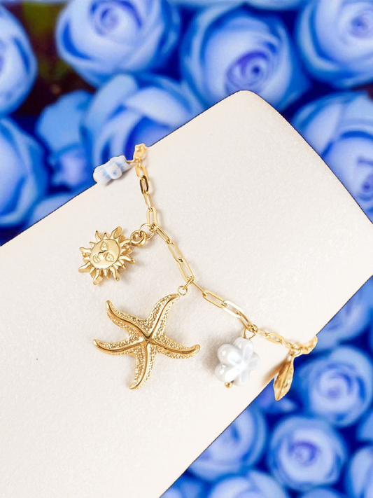 Bracelet chaîne dorée breloques de la mer fleurs bleues
