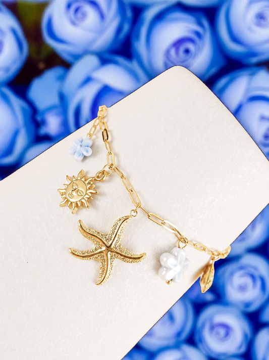 Bracelet chaîne dorée breloques de la mer fleurs bleues